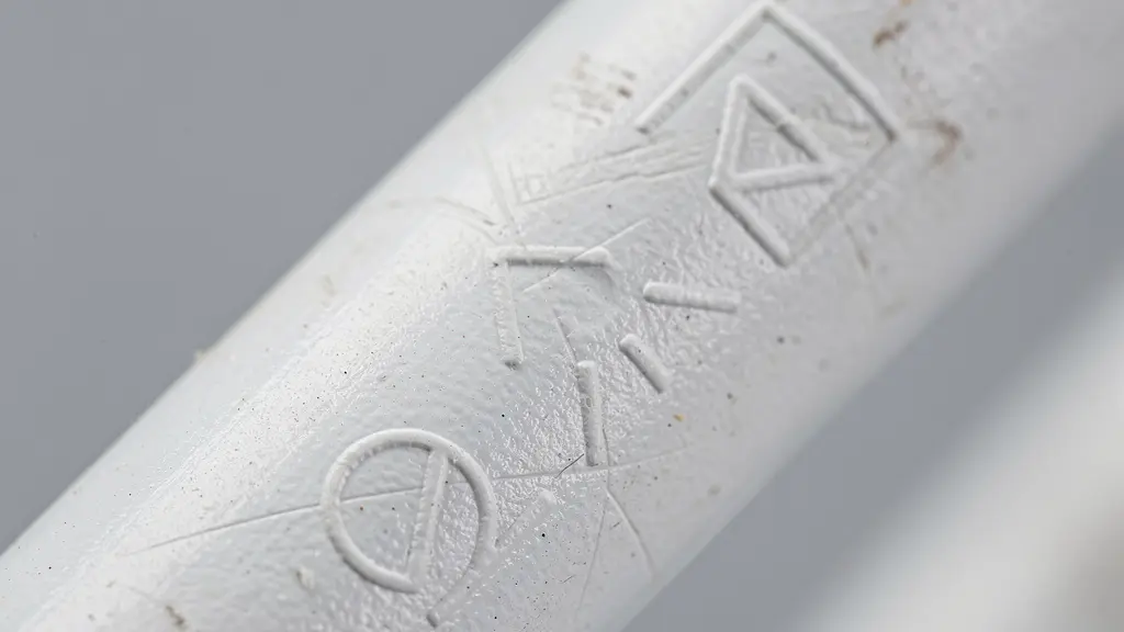 Vue macro d'un marquage NF authentique gravé sur la surface d'un tuyau PVC blanc avec texture visible