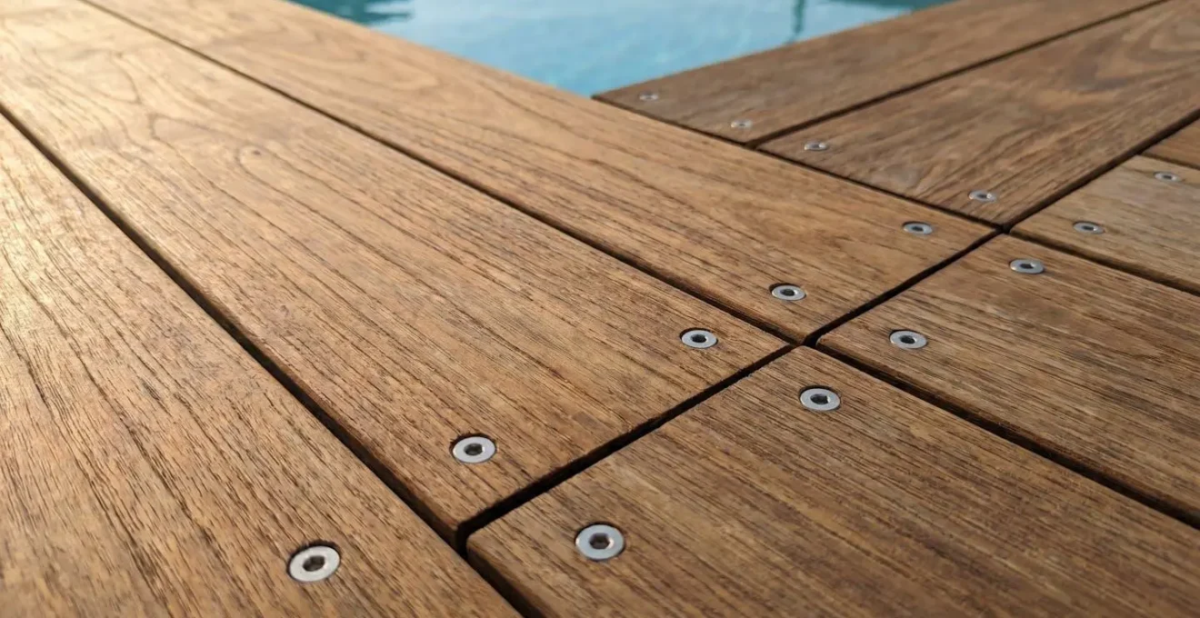 Gros plan sur les planches d'une piscine en bois avec assemblage visible en vis inoxydables et texture du bois traité